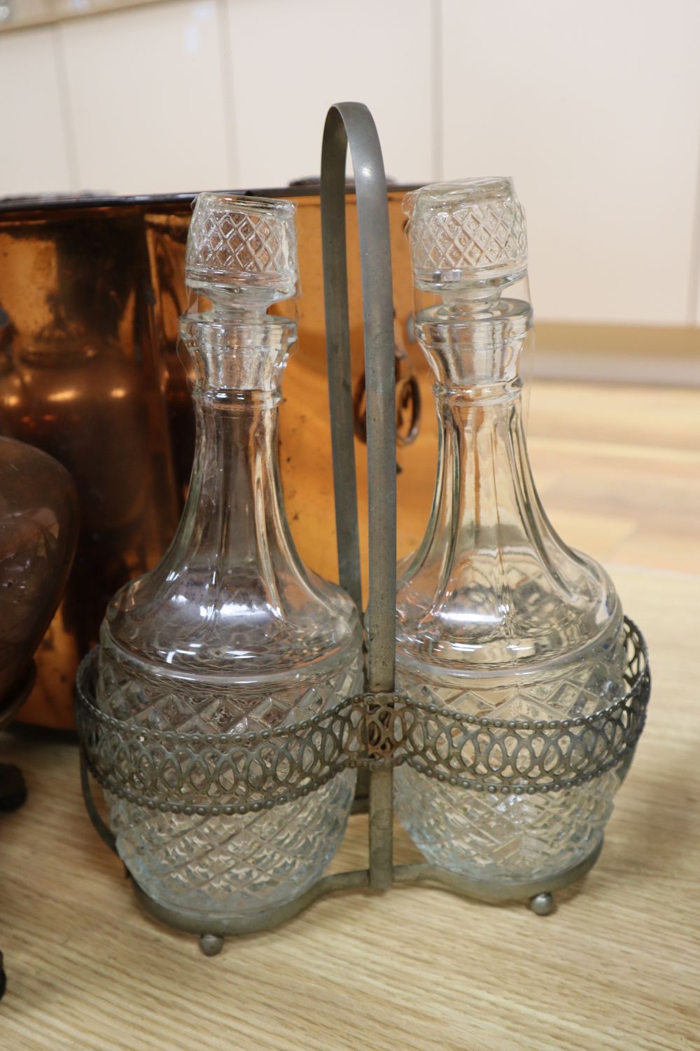 A Christopher Dresser style plated kettle, a copper coal box, a copper kettle and a plated two-bottle decanter stand